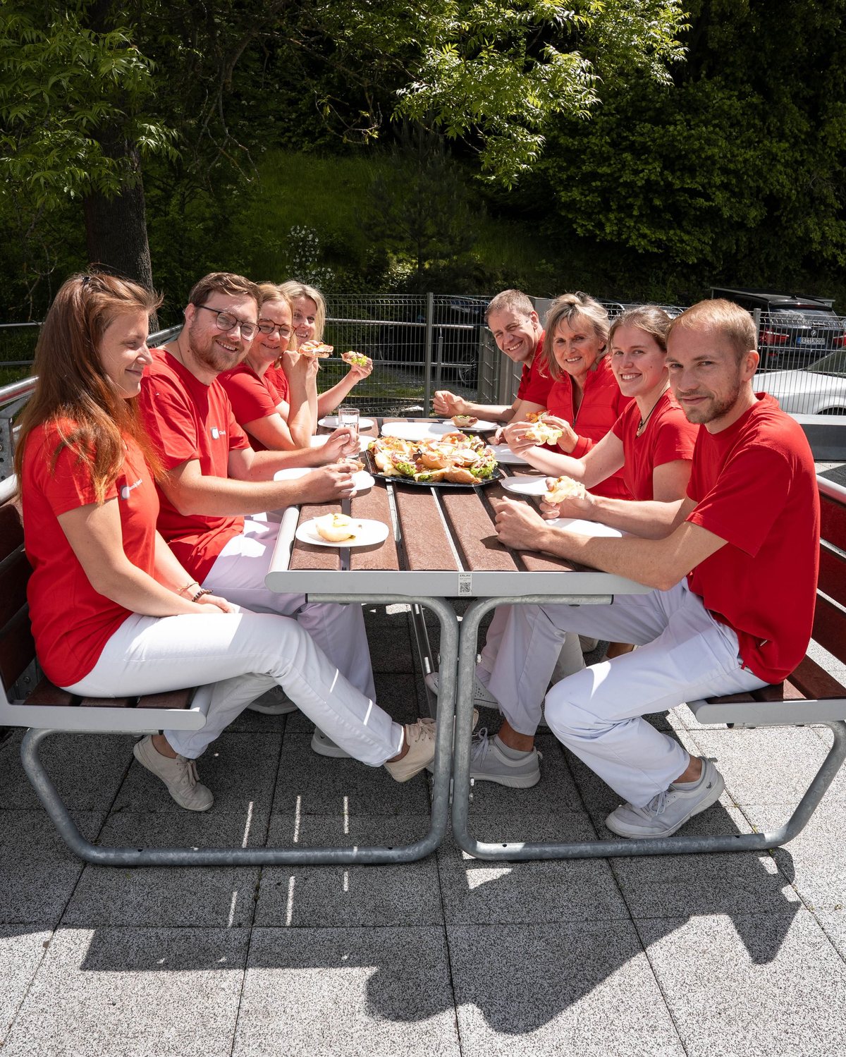 Das Team der Dental Family in der Mittagspause an einem Tisch im Freien